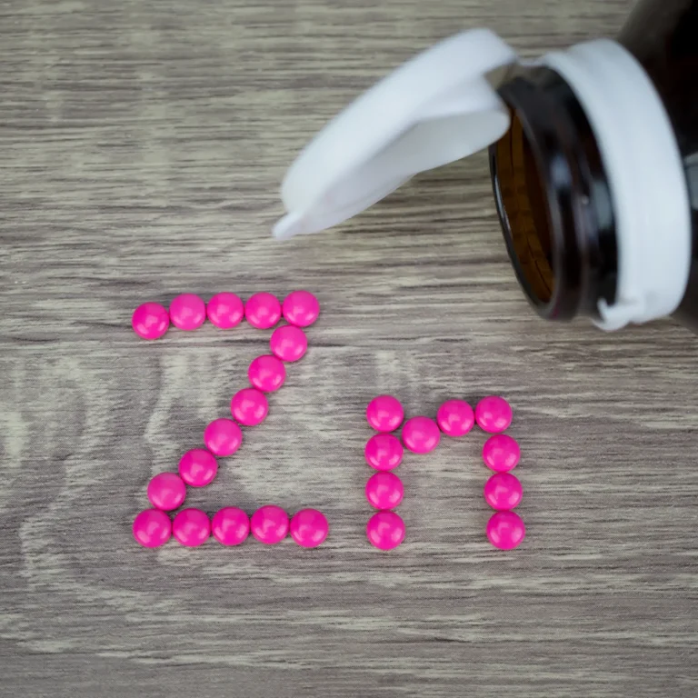 Can anyone take zinc supplements A selection of pink pills spelling out ‘Zn’, the chemical symbol for zinc, near an open pill bottle.