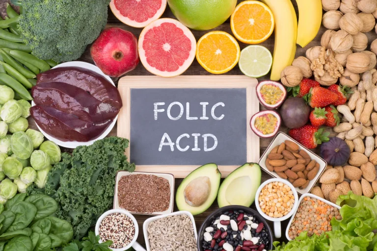 Can men take folic acid Examples of various healthy foods, including many that are rich in folate, surrounding a chalkboard reading ‘folic acid’.