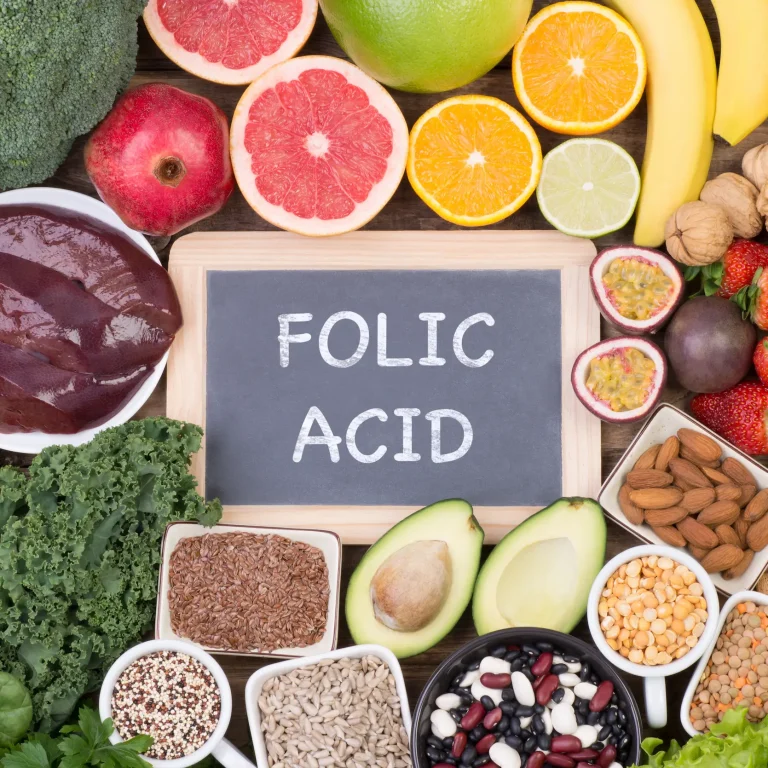 Can men take folic acid Examples of various healthy foods, including many that are rich in folate, surrounding a chalkboard reading ‘folic acid’.