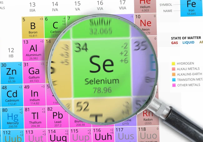 A magnifying glass hovers over selenium on a close-up of the periodic table.