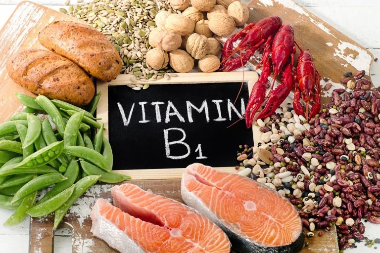 Which Food Contains Vitamin B1 A selection of healthy foods including sources of thiamin, surrounding a chalkboard that reads ‘vitamin B1’.