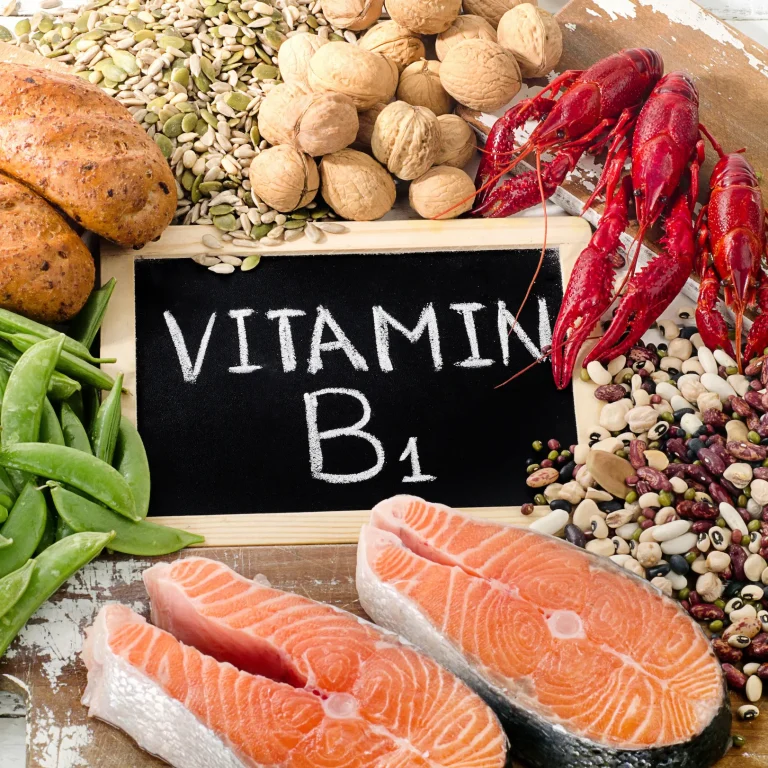 Which Food Contains Vitamin B1 A selection of healthy foods including sources of thiamin, surrounding a chalkboard that reads ‘vitamin B1’.