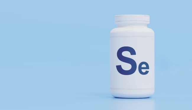 A white pill bottle, labelled ‘Se’ for selenium, against a light blue background.