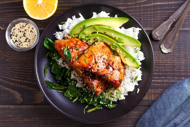A tasty, home-cooked and nutrient-rich meal of salmon teriyaki rice with avocado and spinach.