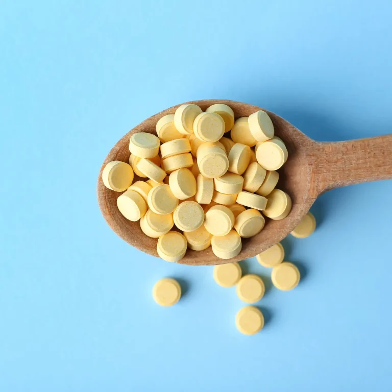 A wooden spoon holding dozens of folic acid tablets, an excessive dose.
