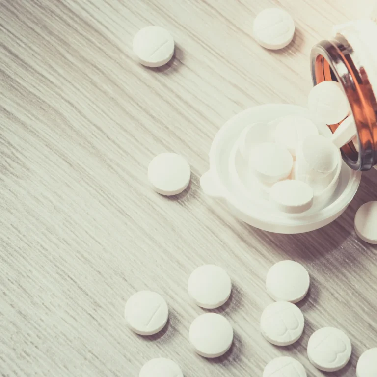 Can you overdose on zinc supplements Pills spill out of a bottle onto a wooden table, representing an excessive dose.