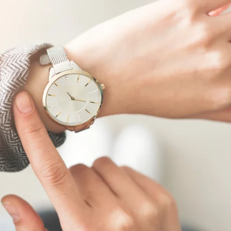A woman checks the time on her wristwatch, representing waiting to see results.