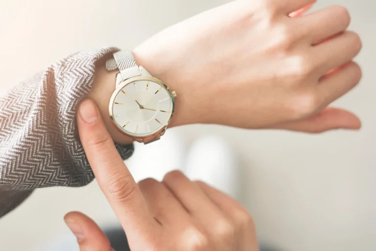A woman checks the time on her wristwatch, representing waiting to see results.
