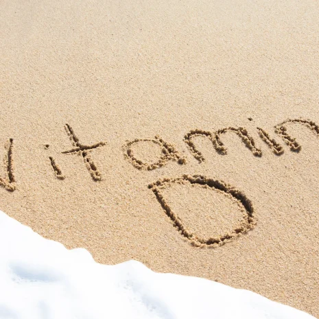 The words ‘Vitamin D’ written in the sand, with waves about to wash it away