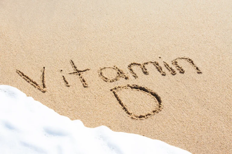 The words ‘Vitamin D’ written in the sand, with waves about to wash it away