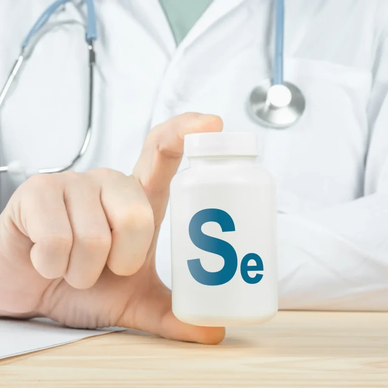Close-up of a doctor holding a white pill bottle labelled ‘Se’ for selenium.