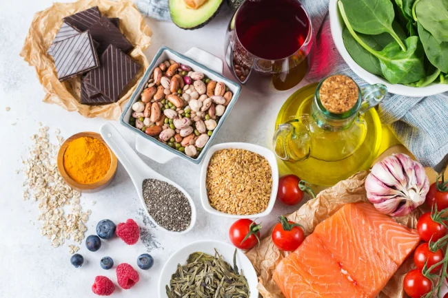 A range of foods with healthy fats, including salmon, olive oil, nuts and avocado.