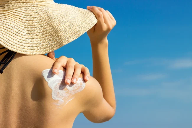 A woman applies sunscreen to her bare shoulder; one way of reducing oxidative stress. A woman applies sunscreen to her bare shoulder; one way of reducing oxidative stress.